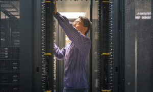Network IT professional in server room working on racks