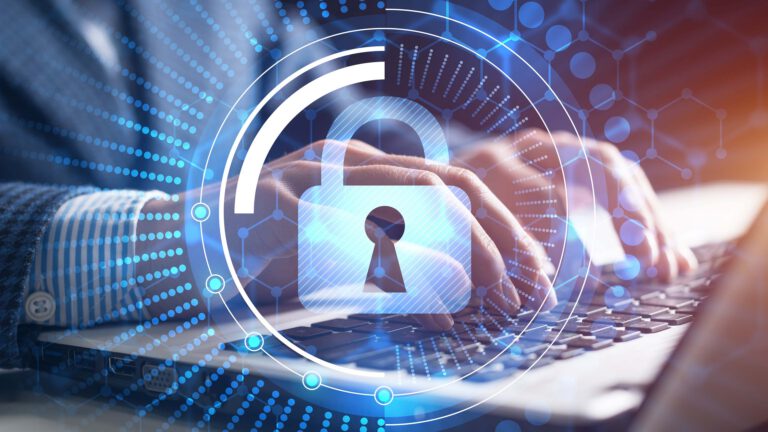 Business man typing on a laptop with a security shield icon superimposed over the image